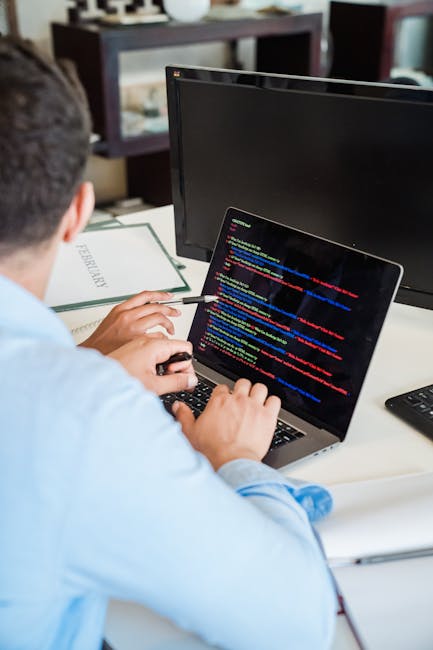 This image shows a woman with medium-length dark hair wearing a black jacket over a purple top, holding an open technical book titled 'Dynamic HTML' which features an illustration of a flamingo on the